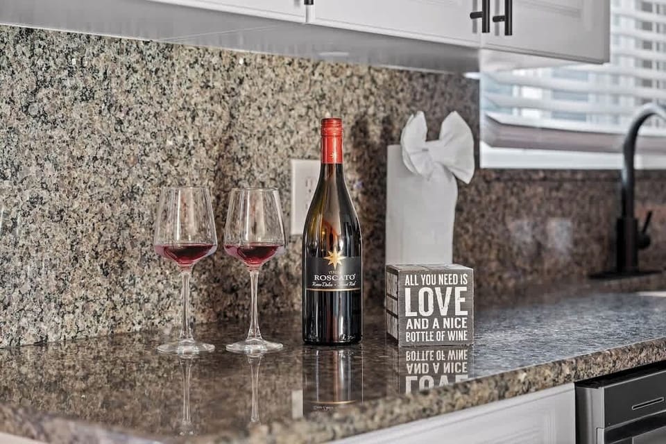 Elegant wine glasses and a bottle ready for your enjoyment in the kitchen (wine not included).