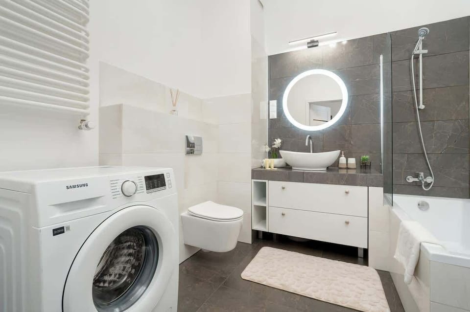 Bathroom includes a washing machine, vanity sink, and walk-in shower – especially convenient for longer stays.

