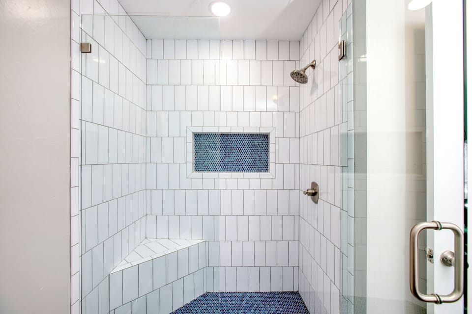 This shower features a sleek, modern design with plenty of space to rinse off after a day at the beach.