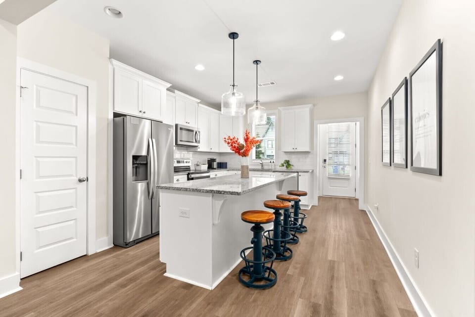 Spacious chef`s kitchen with oversized island seating, stainless appliances, and plenty of room to gather.