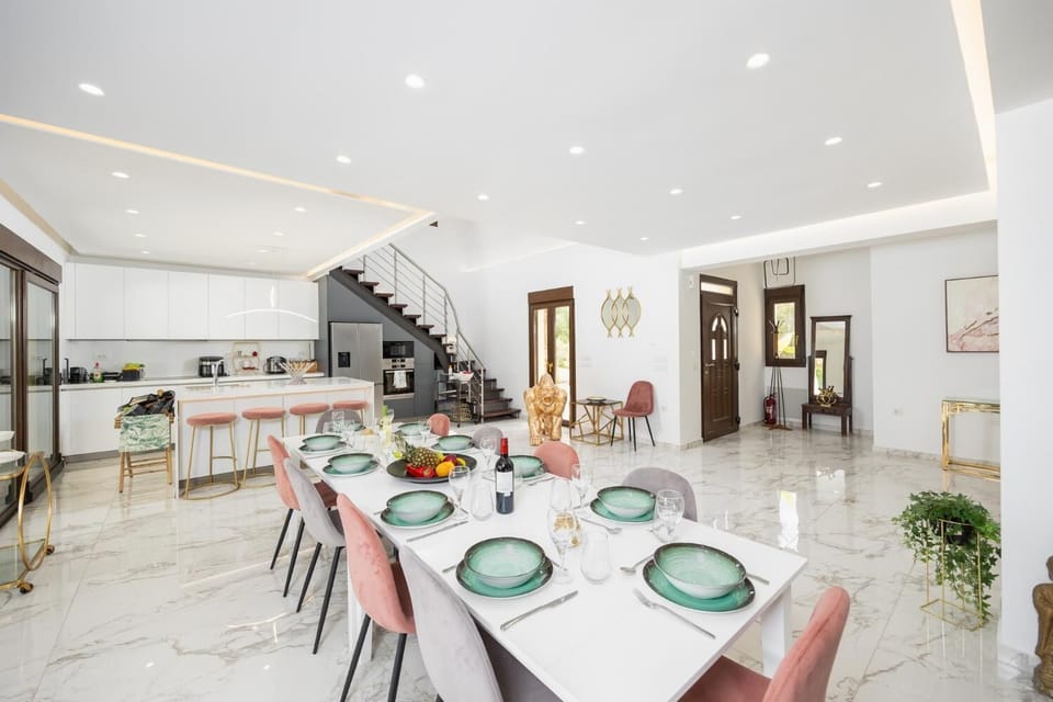 Open-plan living room with sofas, dining area, kitchen, ornamental fireplace, A/C, WiFi internet, satellite TV, and mezzanine