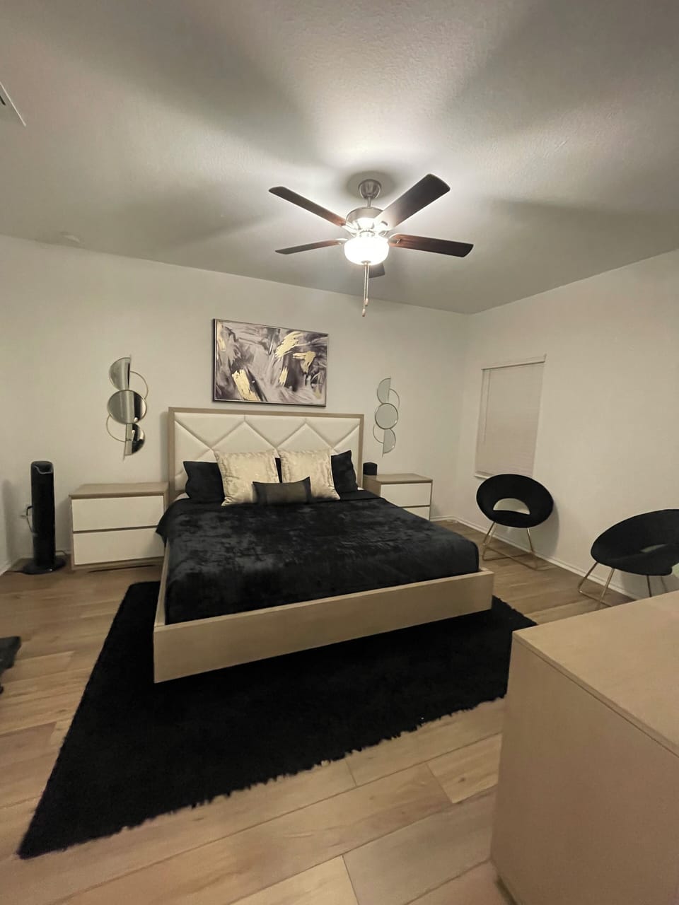 Primary bedroom on first floor with king bed, ceiling fan, 2 nightstands