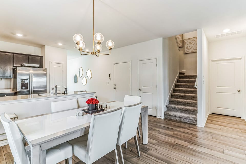 Dining room with 6 chairs and 2 bar stools at the kitchen island