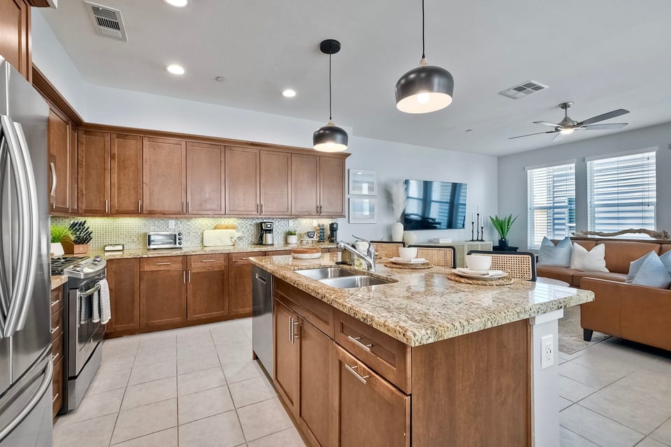Prepare culinary delights in this fully stocked kitchen with a stainless steel refrigerator, gas stove, oven, microwave, and dishwasher