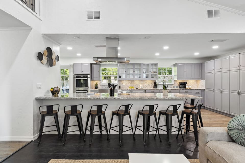 Spacious full kitchen: gray shaker cabinets, granite island & bar seating