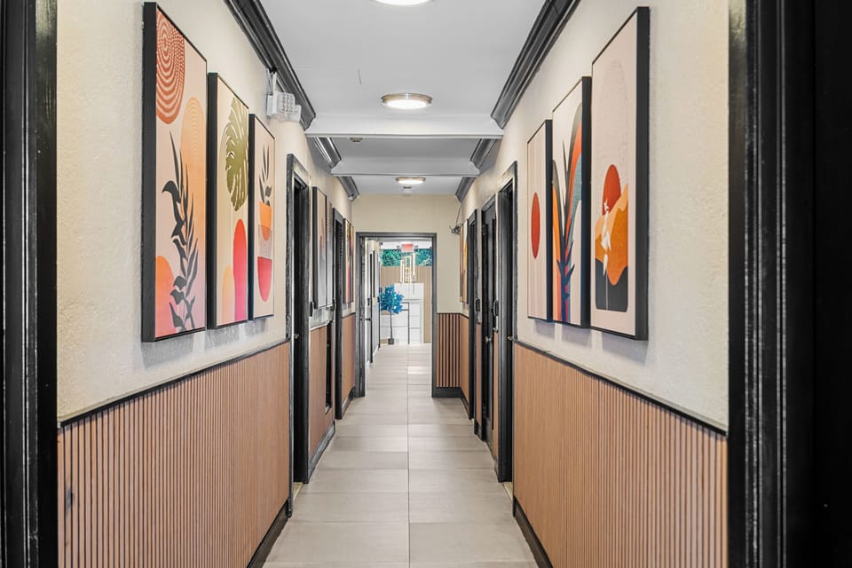 The hallway leading to the guest rooms is adorned with modern art, clean lines, and stylish lighting. The sleek design complements the overall modern aesthetic of the property, making the walk to your room a pleasant experience.