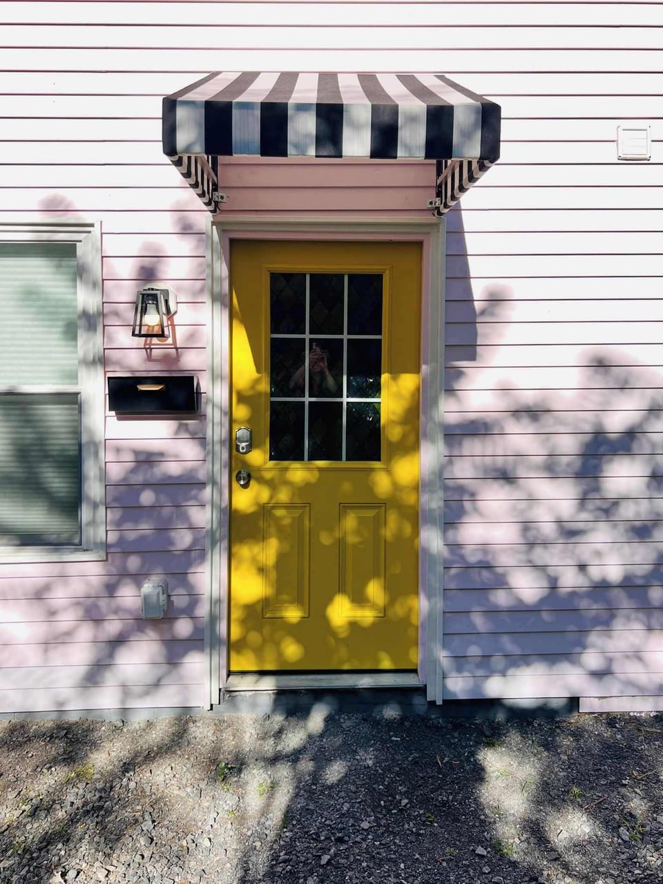 [Main Door] Bright yellow with a cozy roof and smart lock. Welcoming you home with a warm glow!
