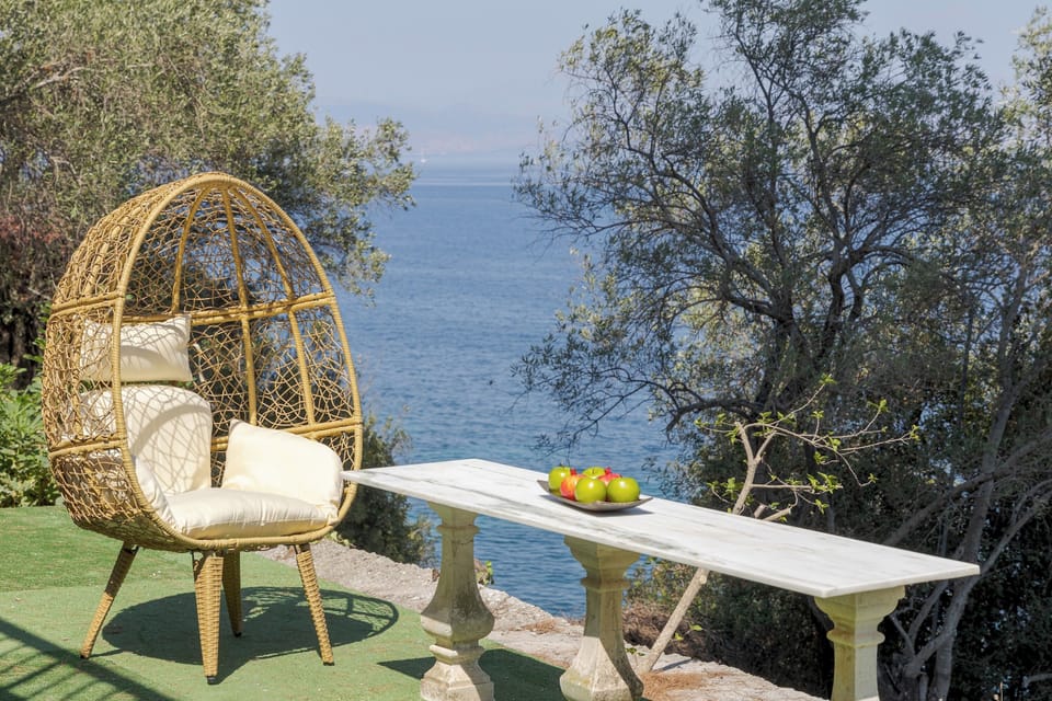 Poolside calm with sunloungers, olive trees, and a sea glimpse