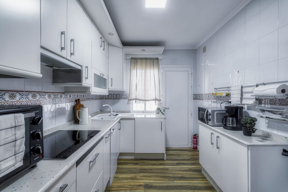 Modern kitchen fully equipped with necessary appliances and utensils.