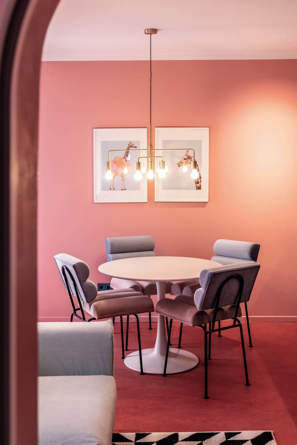 Warm pastel walls and sculptural seating create a welcoming, design-driven living area.