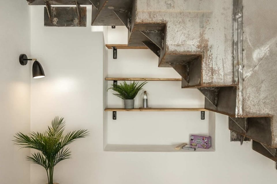 Signature factory loft with raw steel staircase, exposed brick and warm natural light.