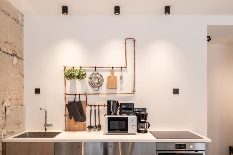 Fully equipped stainless-steel kitchen blending industrial texture with modern comfort.