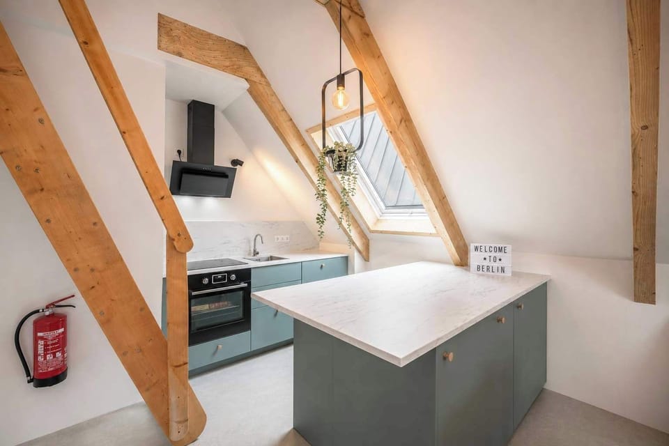 Open kitchen with loft staircase leading to the upper bedroom