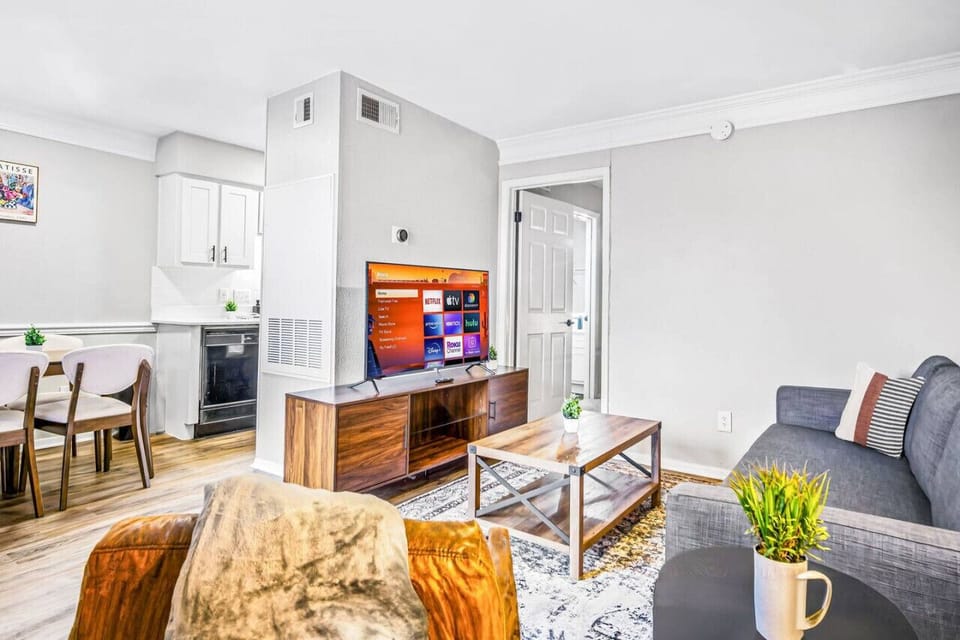 Bright and airy living room with plush seating, a large TV, and tasteful decor, creating the perfect space for relaxation and entertainment.