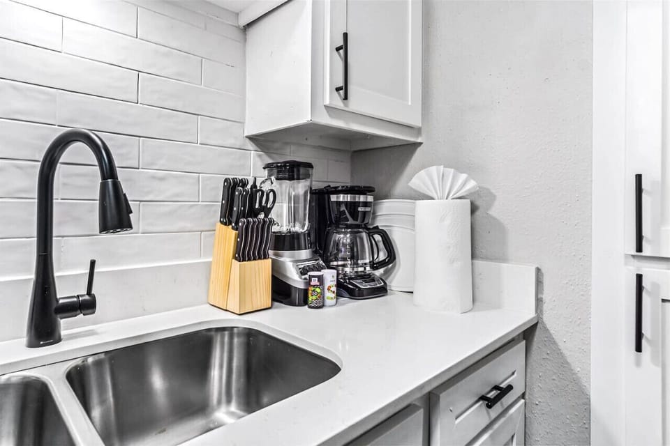 Cook with ease in this well-equipped kitchen featuring stainless steel appliances, ample cabinetry, and a stylish backsplash. Whether you're brewing coffee or preparing a gourmet meal, this space is designed for functionality and style, making every meal