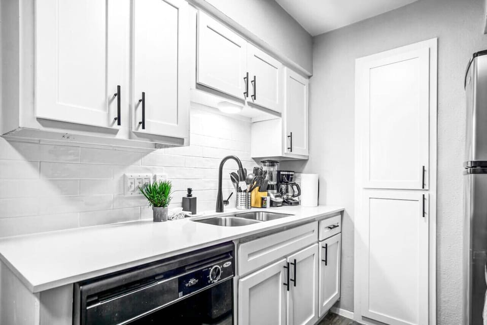 Cook with ease in this well-equipped kitchen featuring stainless steel appliances, ample cabinetry, and a stylish backsplash. Whether you're brewing coffee or preparing a gourmet meal, this space is designed for functionality and style, making every meal