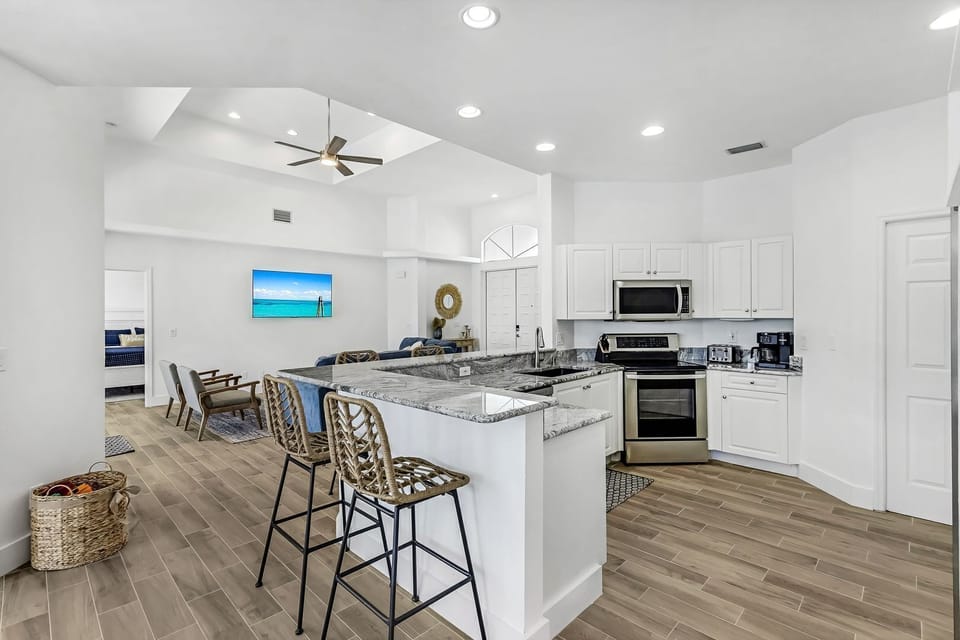 Open concept kitchen with 4 barstools at the breakfast bar