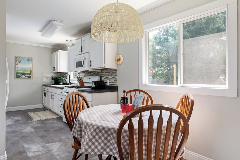 The dining table is positioned near a large window that allows natural light to fill the space.