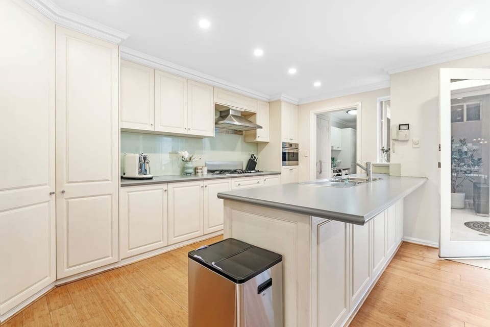 Prepare delicious meals in this bright, fully equipped kitchen with ample counter space, a large central island, a built-in oven, and a gas cooktop.