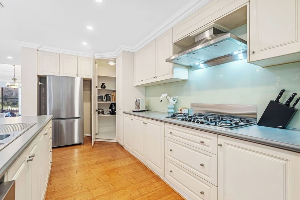 Prepare meals effortlessly in this bright kitchen with a five-burner gas cooktop, and a spacious pantry.