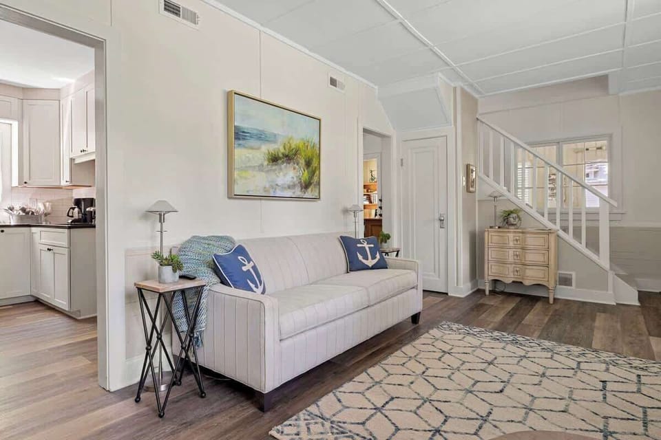 A blend of classic and coastal: the striped couch and anchor pillows offer a fresh, breezy feel, while the rustic chest adds a dash of vintage charm.