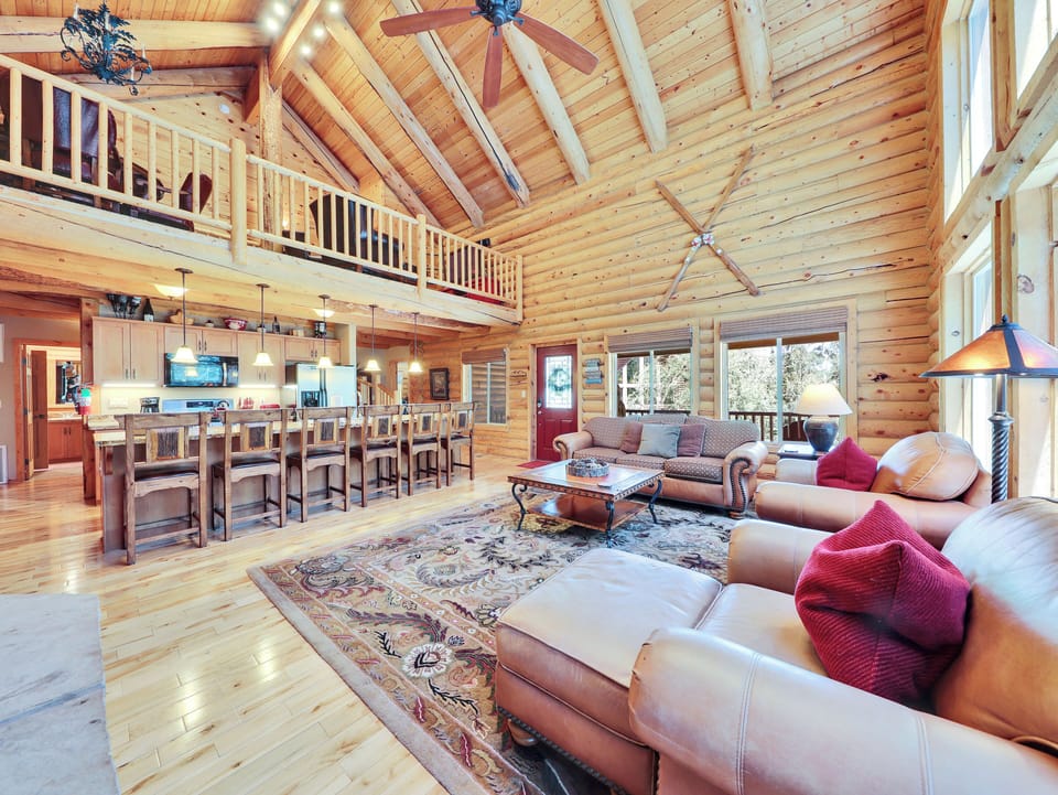 Spacious living room featuring a stunning floor-to-ceiling gas fireplace and expansive forest views