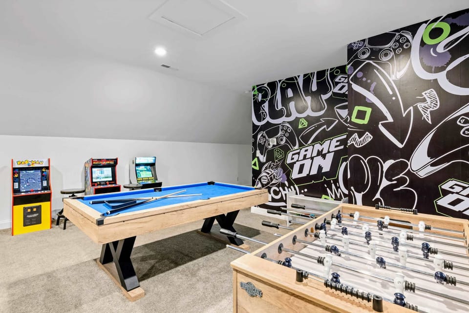 Game Room - Pool table, foosball, and a wall of arcades under a 'GAME ON' mural, this is where rainy days end up.