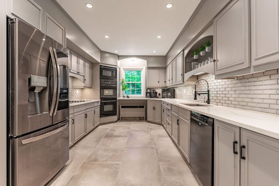 Fully equipped kitchen with Quartz counters, dual ovens, microwave, electric stone, countertop grill, dishwasher, coffee machines, and Air Fryer