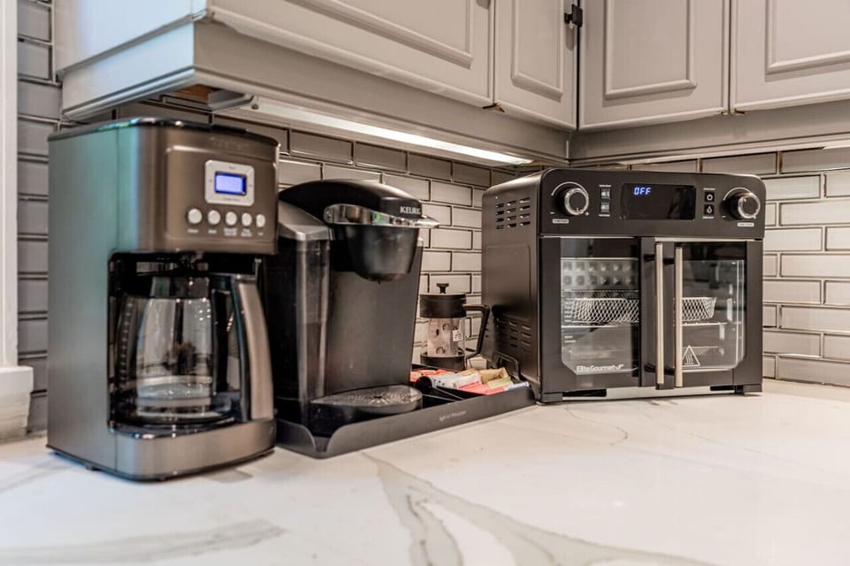 Fully equipped kitchen with Quartz counters, dual ovens, microwave, electric stone, countertop grill, dishwasher, coffee machines, and Air Fryer