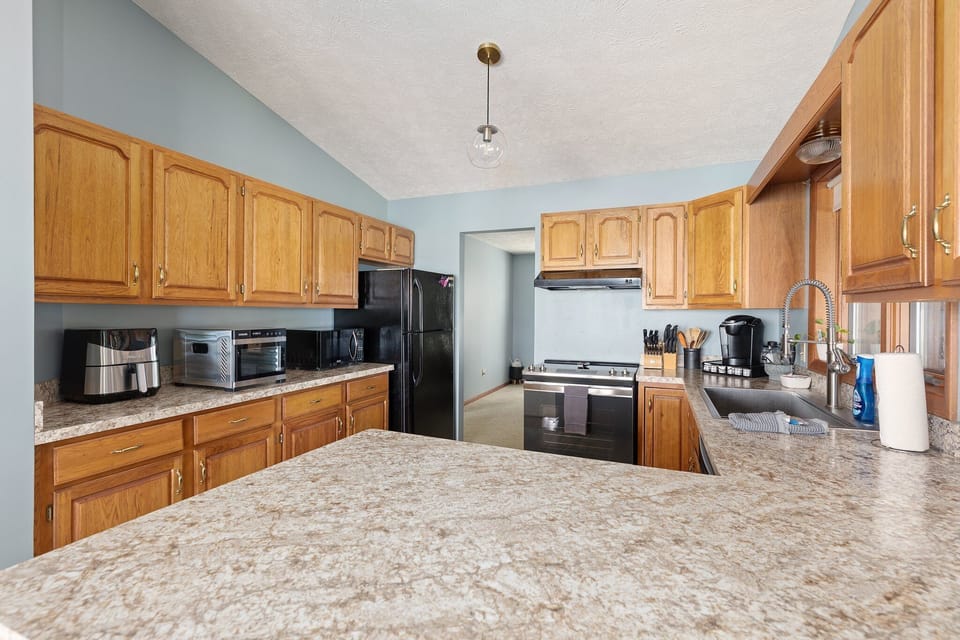Large kitchen w/ wood cabinetry, wraparound counters & plenty of prep space.