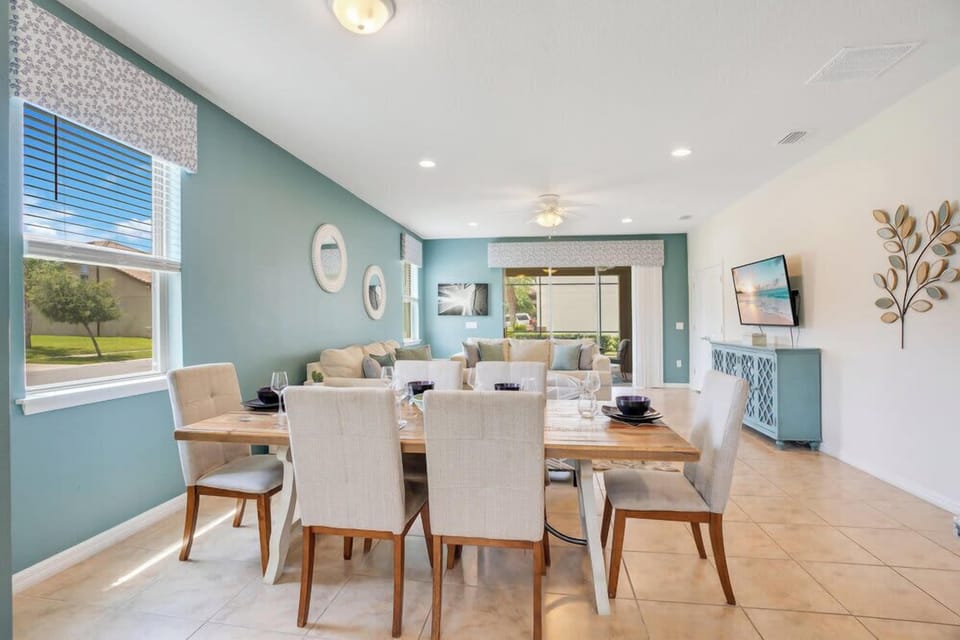 Open-concept dining and living area with natural light and calming blue accents.