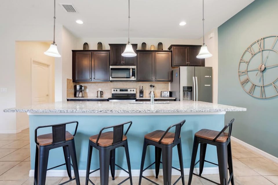 Modern kitchen with granite island and seating for four.