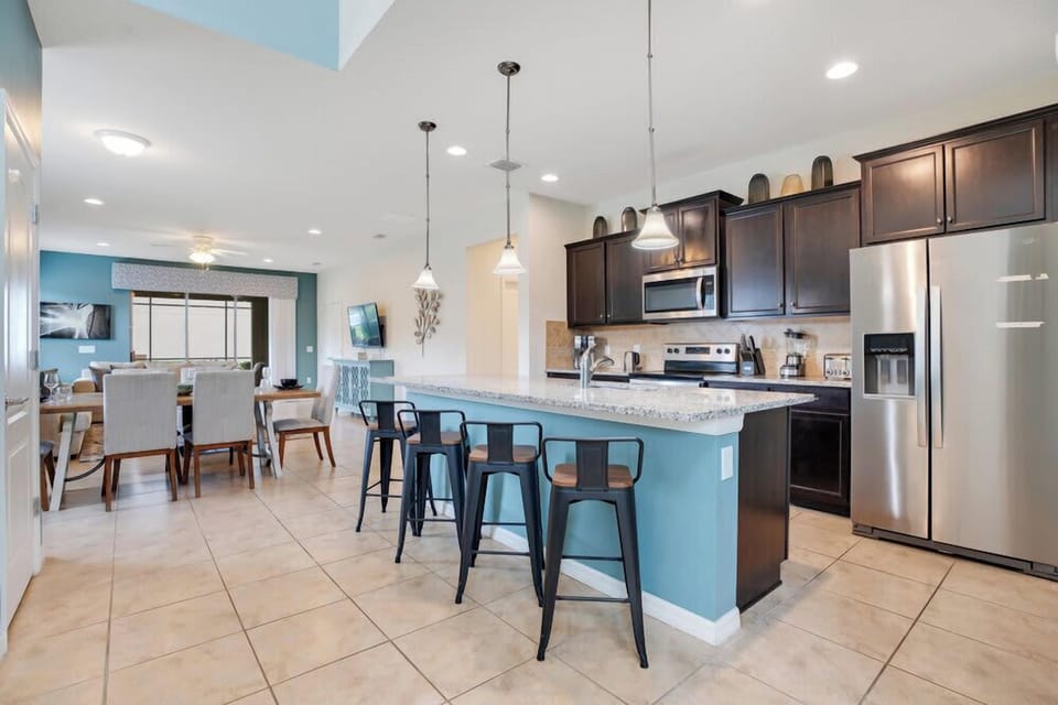 Modern kitchen with a large island and bar seating overlooking the dining area.