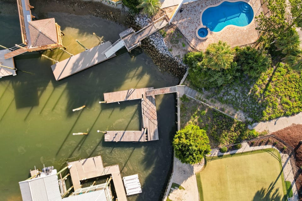 Waterfront property featuring private dock and lush tropical landscaping in a peaceful canal setting.