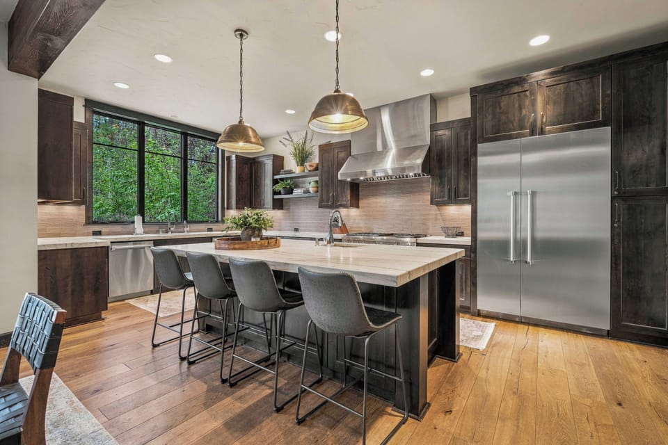 Relax beneath soaring wood-beamed ceilings and warm up by the beautiful stone fireplace, a cozy centerpiece that makes this space feel truly inviting.
