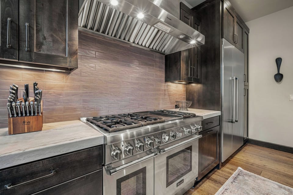 Step into your cozy retreat with rustic wood furnishings and a plush bed dressed in Southwestern-style linens. Large sliding doors frame peaceful forest views, while the fireplace adds warmth and charm.
