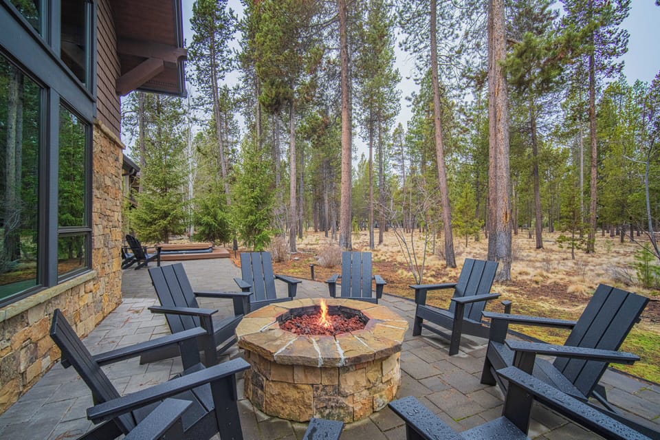 Gather around your private fire pit surrounded by towering pines, where cozy Adirondack chairs invite evening conversations under the stars.