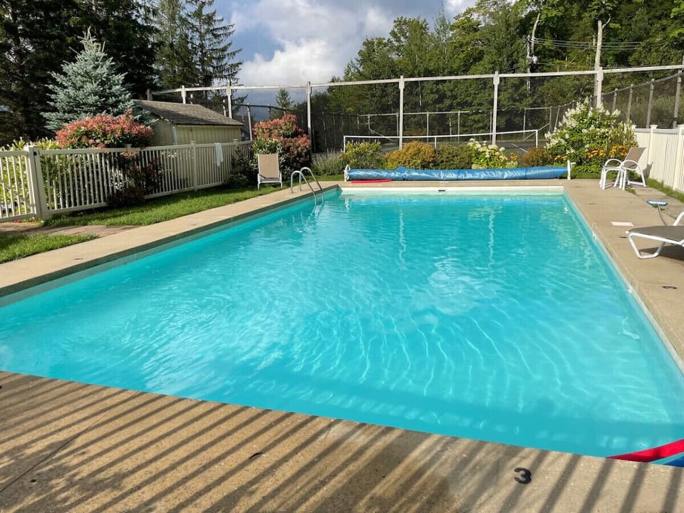 Heated outdoor pool with seating area, open daily from Memorial Day weekend through Labor Day, 9:00 AM – 8:00 PM.