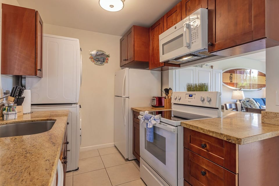 Your fully equipped kitchen features warm cherry cabinets, granite countertops, and modern appliances for all your culinary adventures.