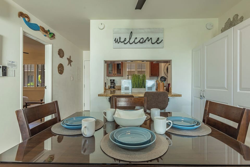 Gather around your welcoming dining table, perfectly set with coastal-style dinnerware and opening to your fully equipped kitchen.