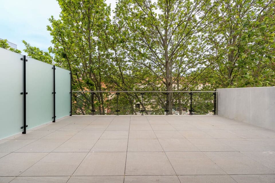 Outdoor balcony with greenery and a pleasant view, perfect for relaxing.
