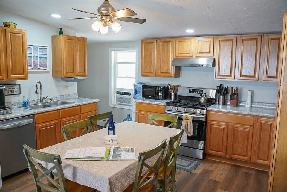 Kitchen highlights include seating for 6, a Keurig coffee machine with provided pods, a dishwasher, complimentary pure spring water dispenser, a microwave, a toaster oven, and plenty of various baking dishes, utensils, and spices.