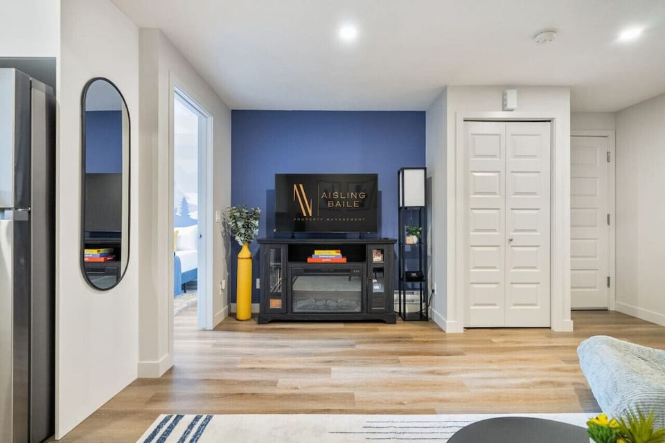 Living room with a double pull-out couch, dining area, electric fireplace & 50` Smart TV.