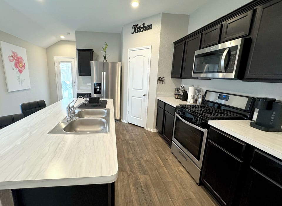 Fully stocked kitchen with stainless steel appliances and a water filter