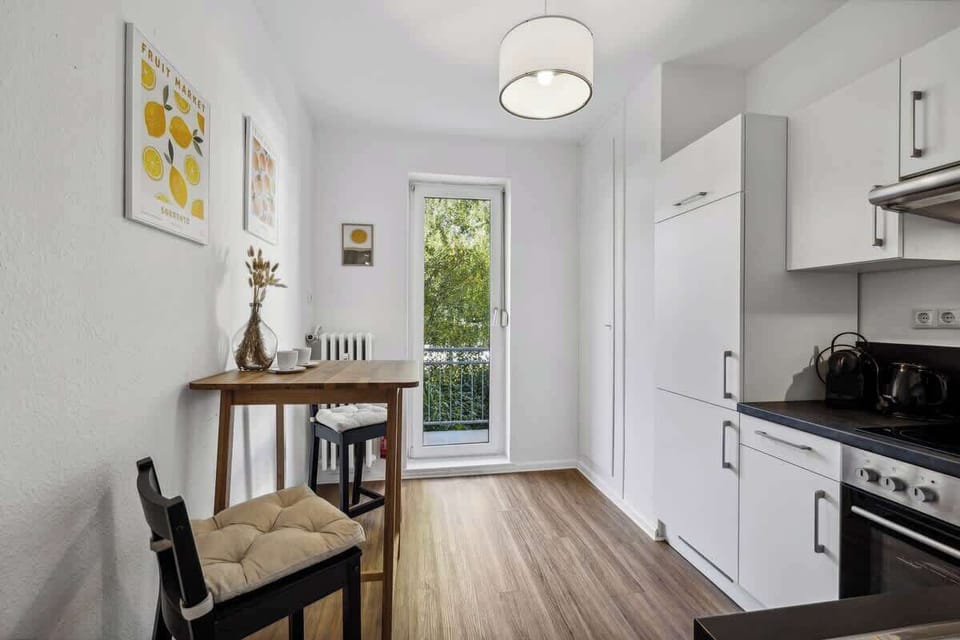 Helle Küche mit gemütlicher Sitzecke und direktem Zugang zum Balkon. Perfekt für den Morgenkaffee oder ein entspanntes Frühstück. Stilvolles, modernes Design mit Blick ins Grüne. Ideal für erholsame Aufenthalte und Selbstversorger.