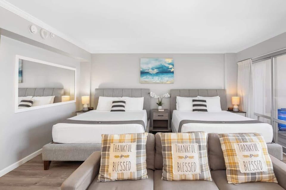 Your condo has 2 queen-size beds, a bedside table and nightstands, a regular sectional sofa, and a wall mirror.