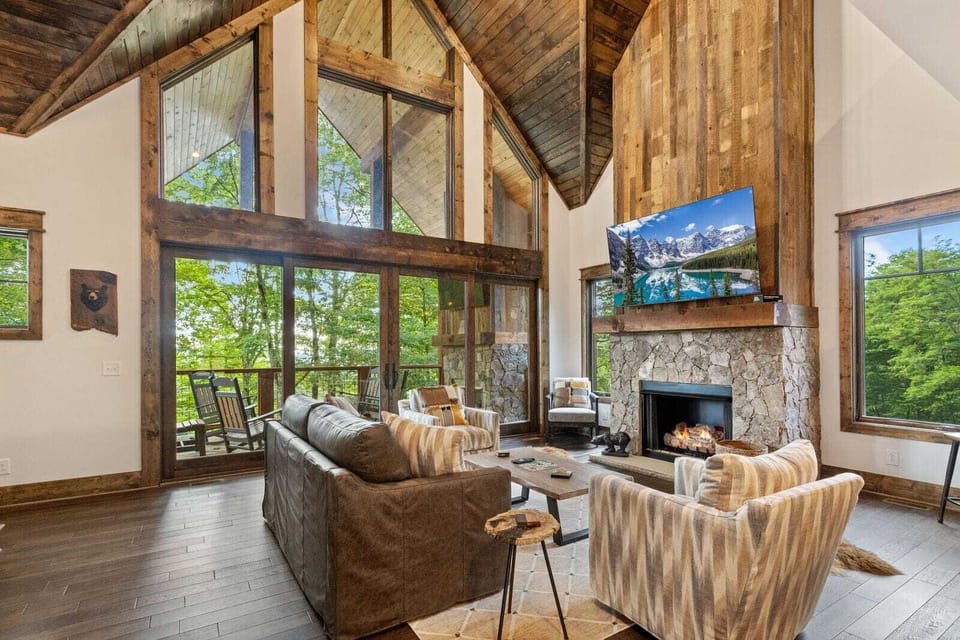 The Great Room has High Vaulted Ceilings, Wood Accents, and a Wall of Windows