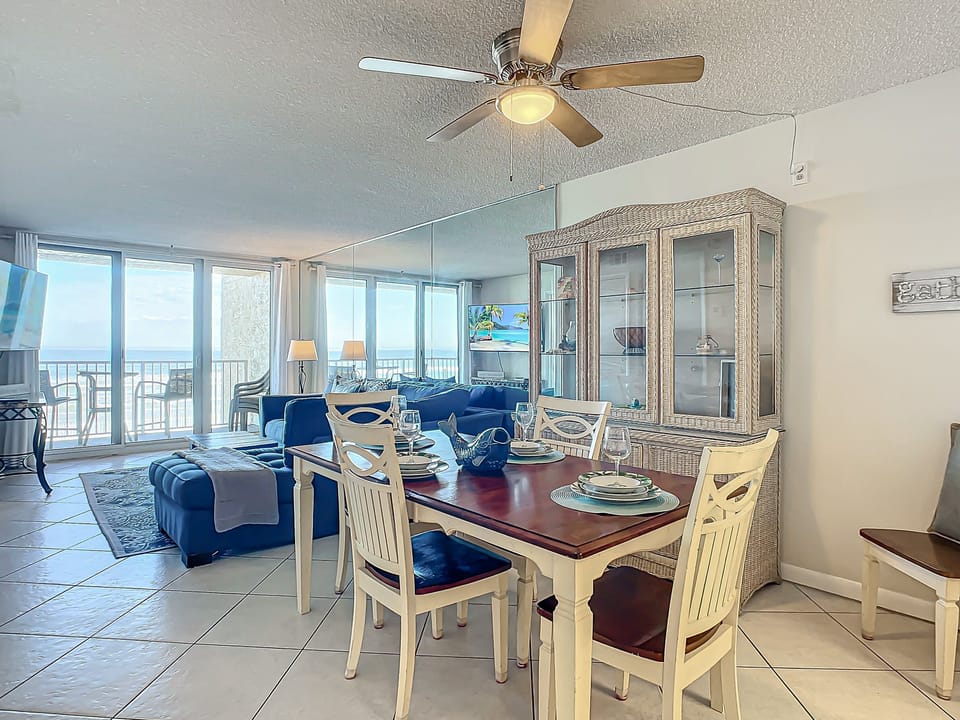 Elegant dining table for four, surrounded by windows offering stunning ocean views and natural brightness.