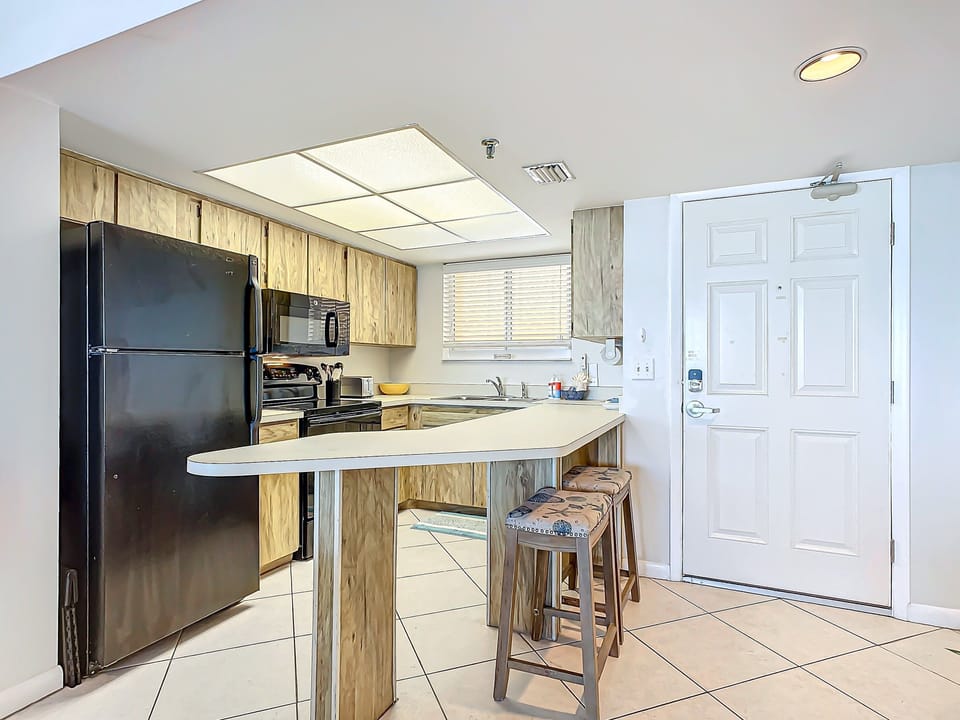 Modern kitchen features a breakfast bar with stylish stools, perfect for casual dining or conversations.