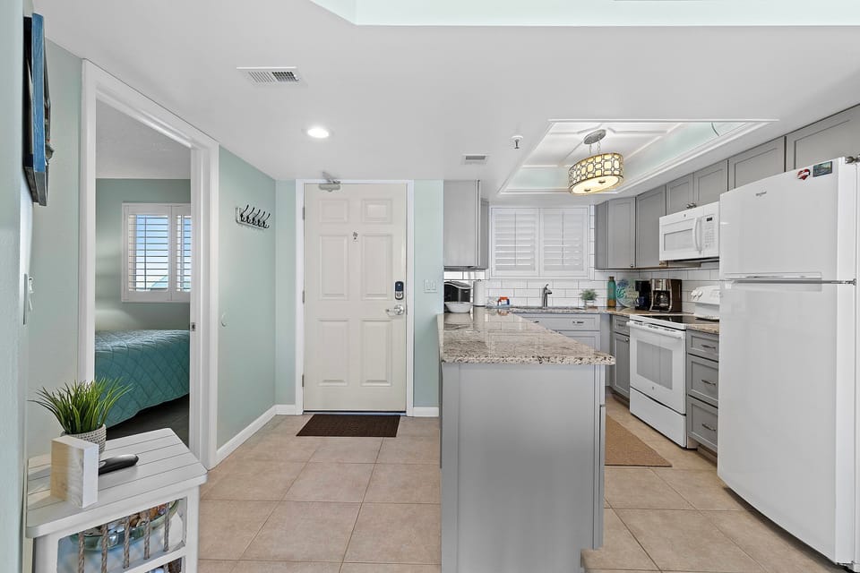 Step into a bright, inviting space leading to a fully equipped kitchen and coastal comforts.